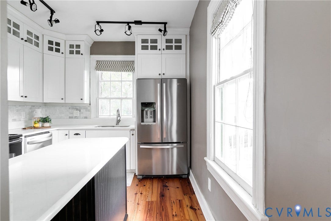 2216 E Marshall Street, Church Hill North, Richmond, VA 23223 Galley kitchen featuring white cabinetry with glass-front upper cabinets, stainless steel French-door refrigerator with ice and water dispensers, white quartz countertops, subway tile backsplash, and hardwood flooring throughout