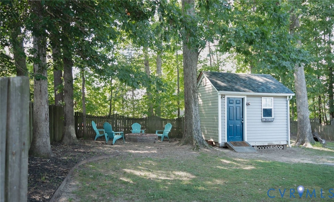 15349 Featherchase Drive, Chesterfield, VA 23832 Detached storage shed with blue door and ramp access, surrounded by mature trees