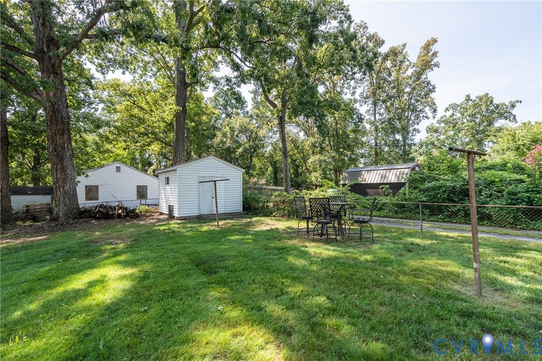 1204 Maywood Road, Beverly Hills, Henrico, VA 23229 Expansive green lawn with mature trees, featuring a white detached shed and a separate white building