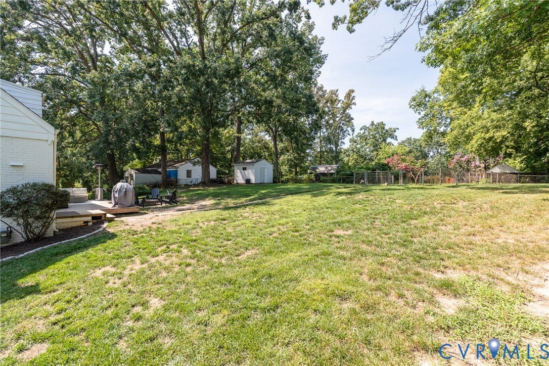 1204 Maywood Road, Beverly Hills, Henrico, VA 23229 Expansive grassy lawn with mature trees, featuring a raised deck, and two detached storage sheds