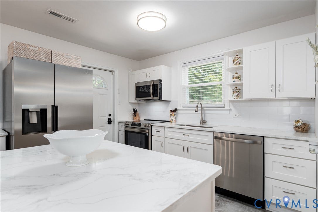 1204 Maywood Road, Beverly Hills, Henrico, VA 23229 White shaker-style cabinetry, stainless steel appliances, white subway tile backsplash, and light-toned countertops