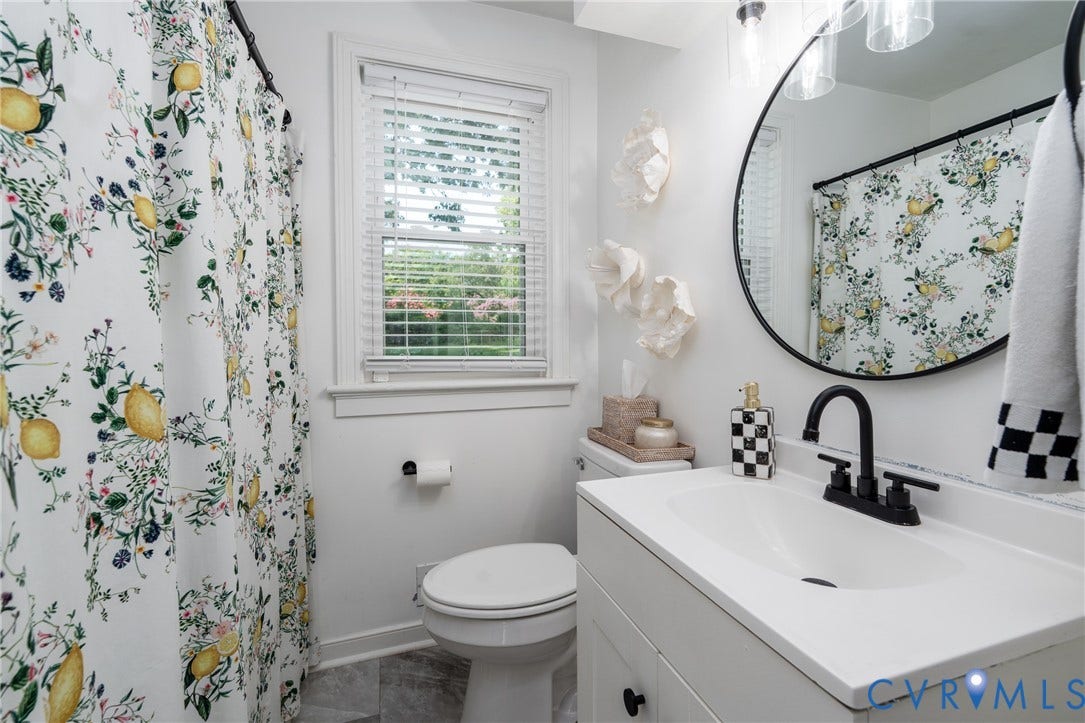 1204 Maywood Road, Beverly Hills, Henrico, VA 23229 White vanity with an integrated sink and matte black faucet, illuminated by a three-light fixture