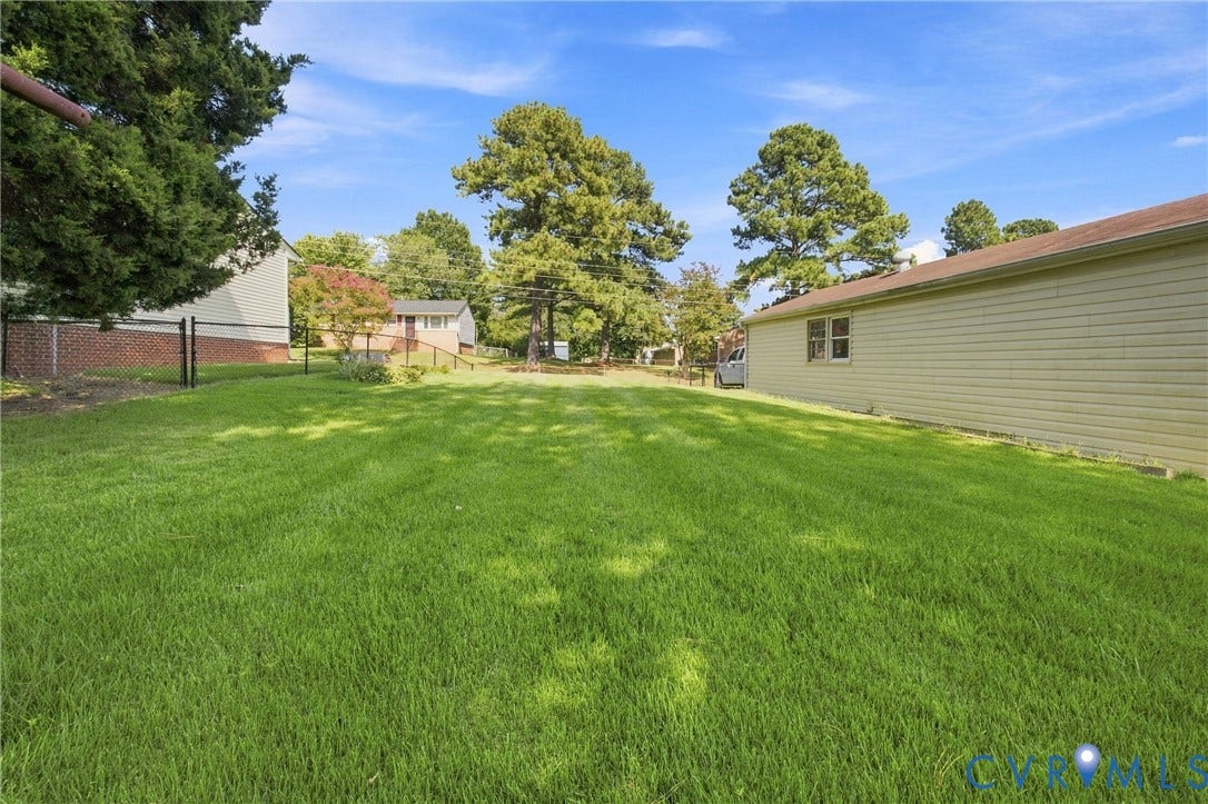 1721 S Halcun Drive, Petersburg, VA 23803 Expansive lawn featuring mature trees and a chain-link fence