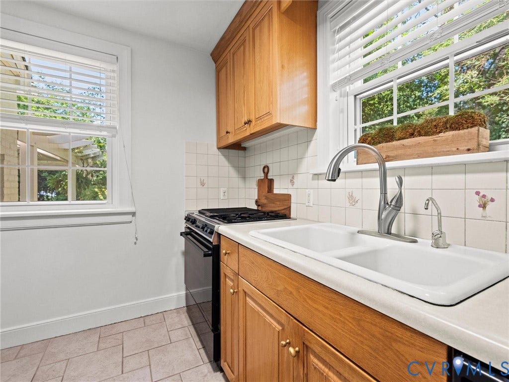 Double basin sink with a gooseneck faucet and separate dispenser