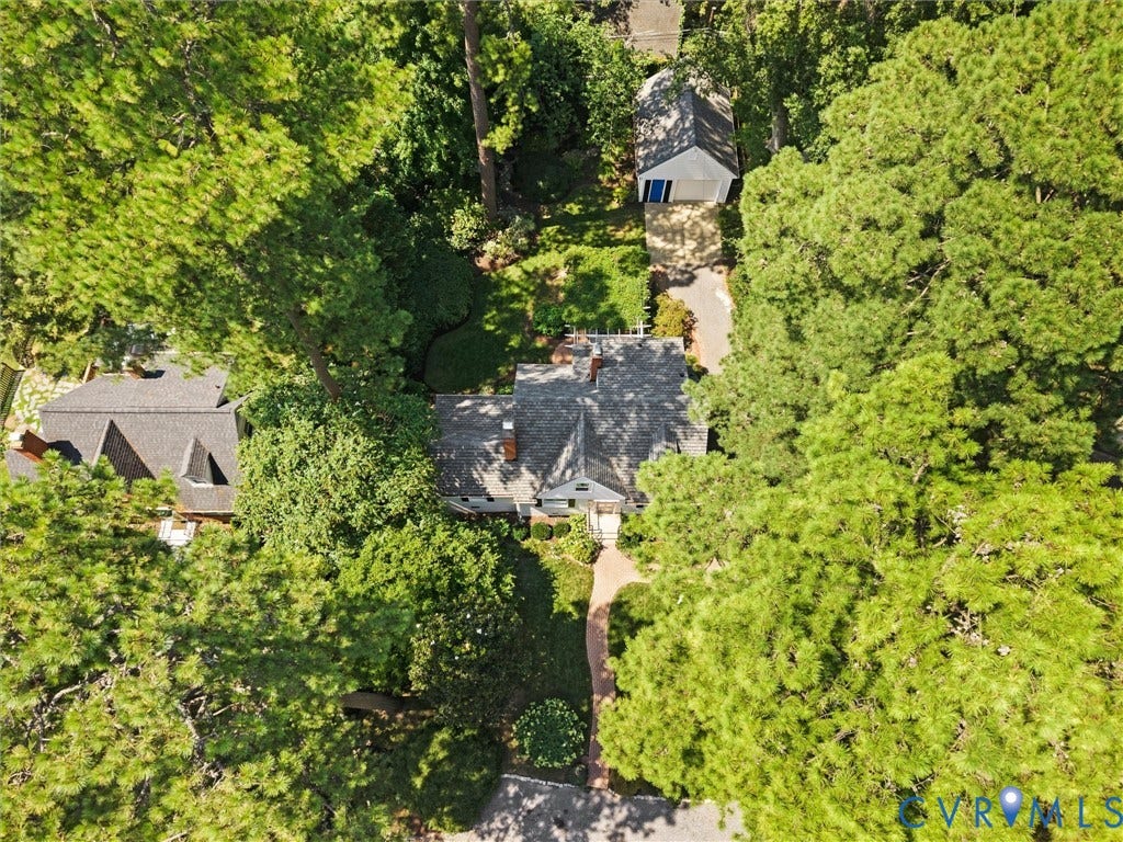 Property featuring a main residence with a shingle roof, established landscaping, and a detached structure
