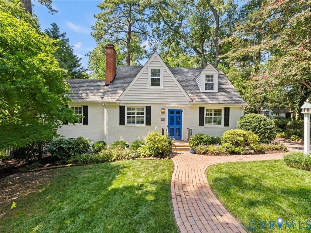 White exterior with black shutters and a prominent blue front door