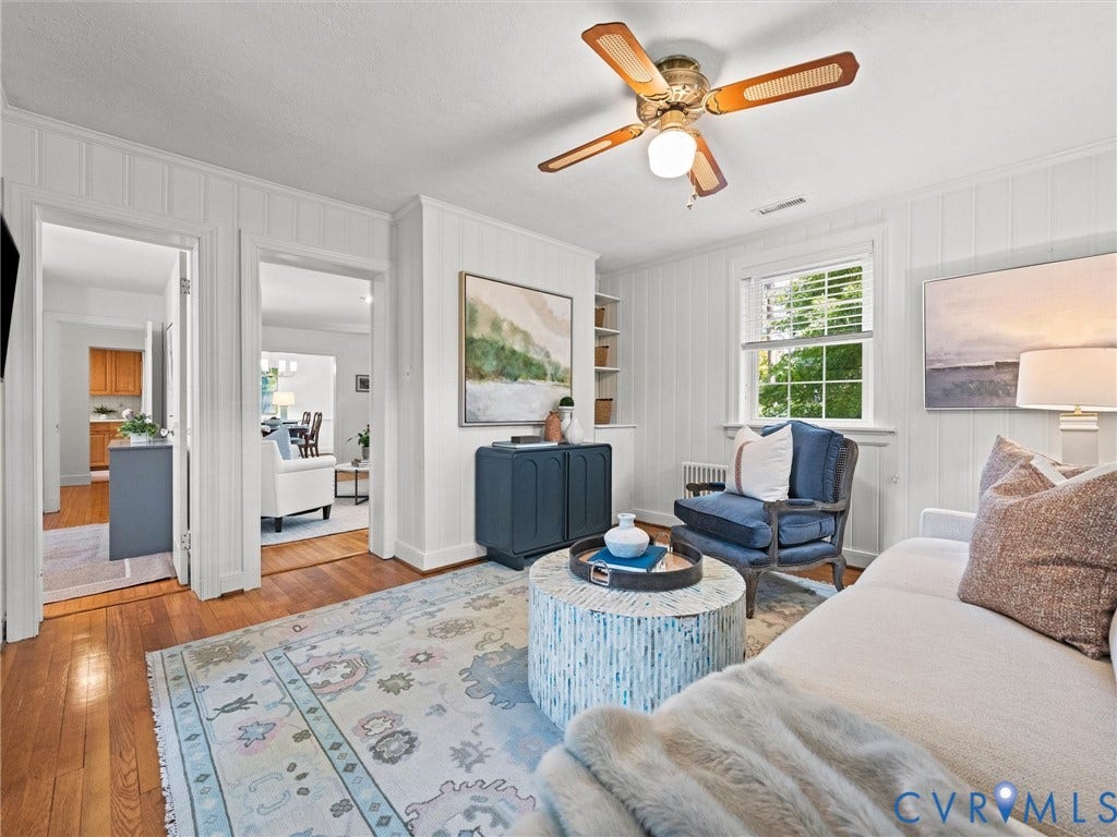 Wood-finish flooring, white paneled walls, ceiling fan with light fixture, and window with blinds