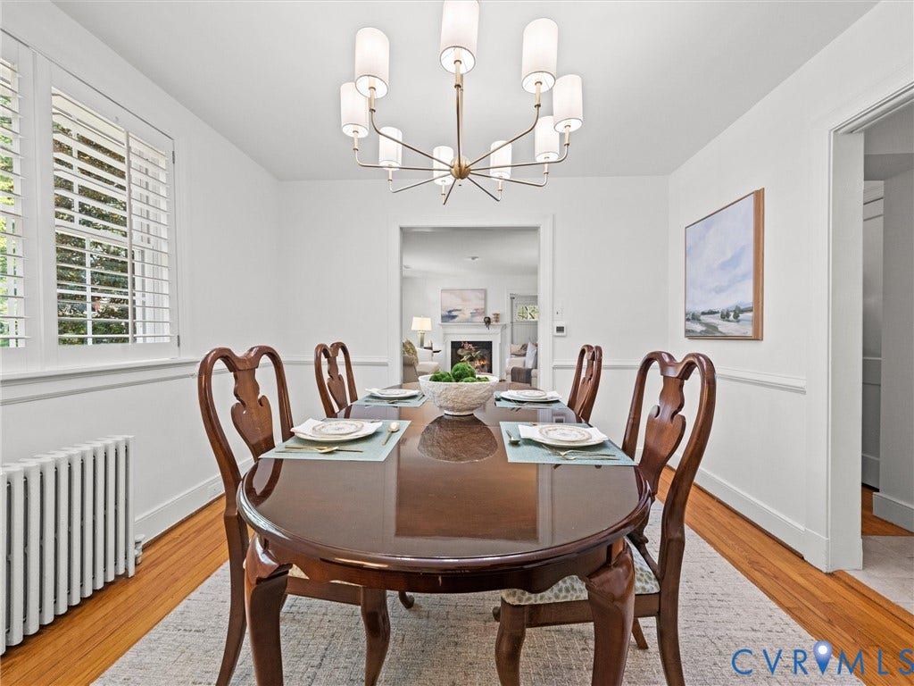 Hardwood flooring, white window shutters, and a modern chandelier