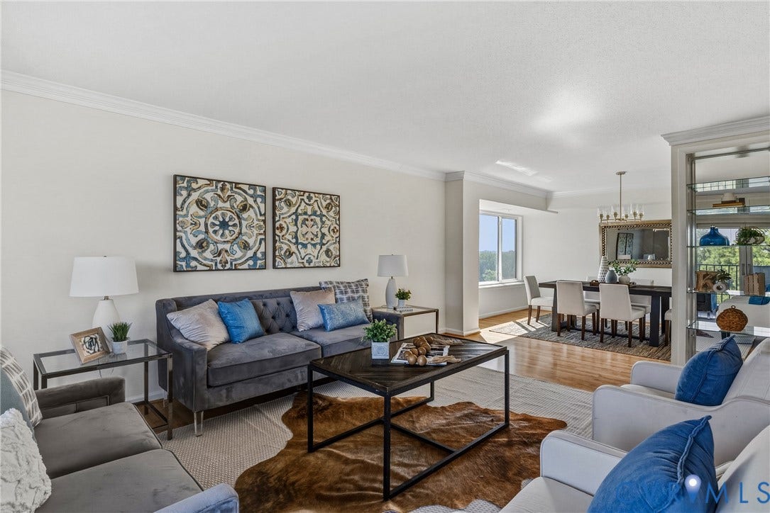 Open concept floor plan with large windows overlooking mature trees