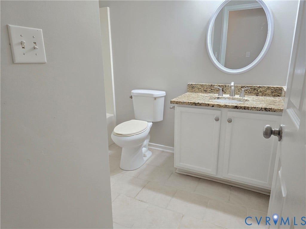 1019 Arizona Drive, Woodhaven, Richmond, VA 23224 White vanity with a stone countertop, an oval mirror, and tile flooring