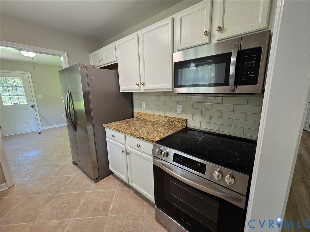 1019 Arizona Drive, Woodhaven, Richmond, VA 23224 White cabinetry, stainless steel appliances, granite-look countertops, subway tile backsplash, and tile flooring