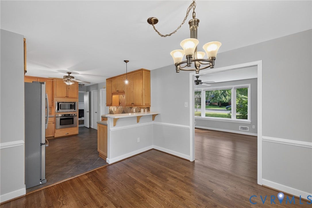 2317 Pleasant Run Drive, Henrico, VA 23238 Hardwood flooring, light gray walls with white chair rail molding, and a kitchen featuring wood cabinetry, stainless steel appliances, and a breakfast bar