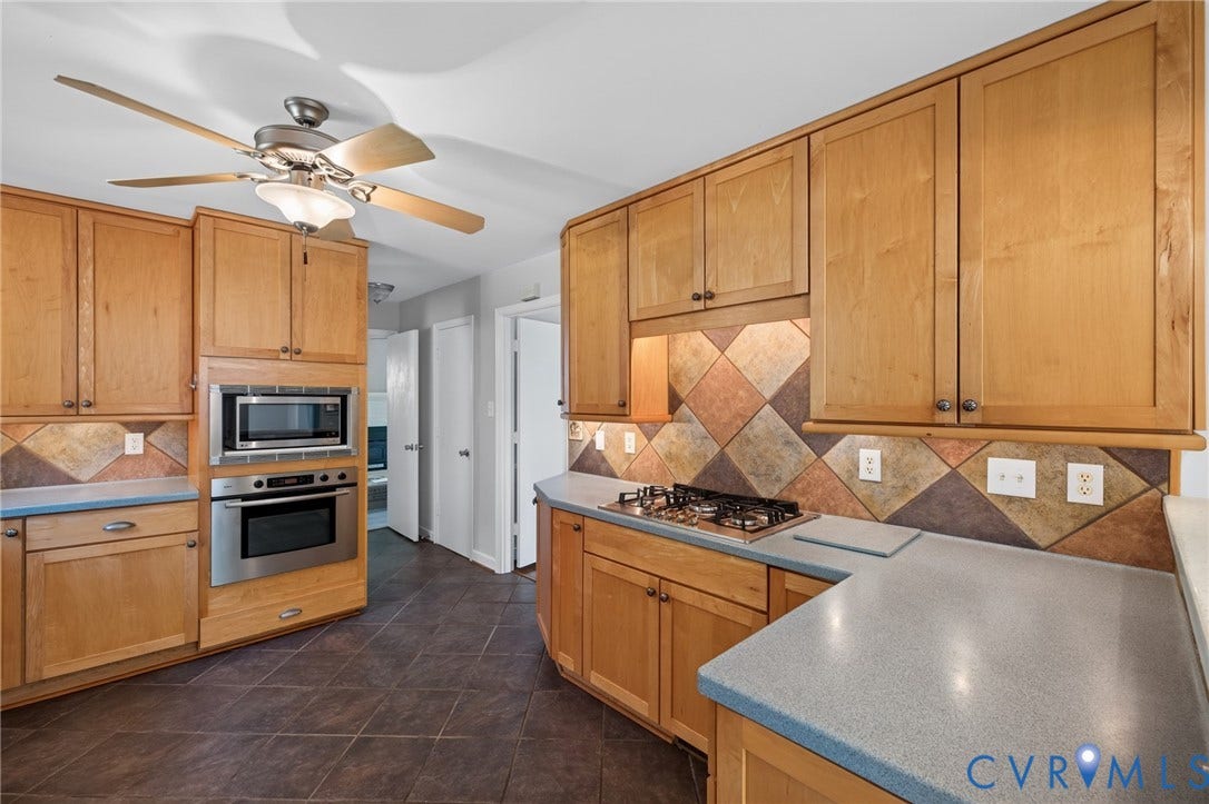 2317 Pleasant Run Drive, Henrico, VA 23238 Wood cabinetry with stainless steel appliances, tile flooring, and a multi-tone tile backsplash