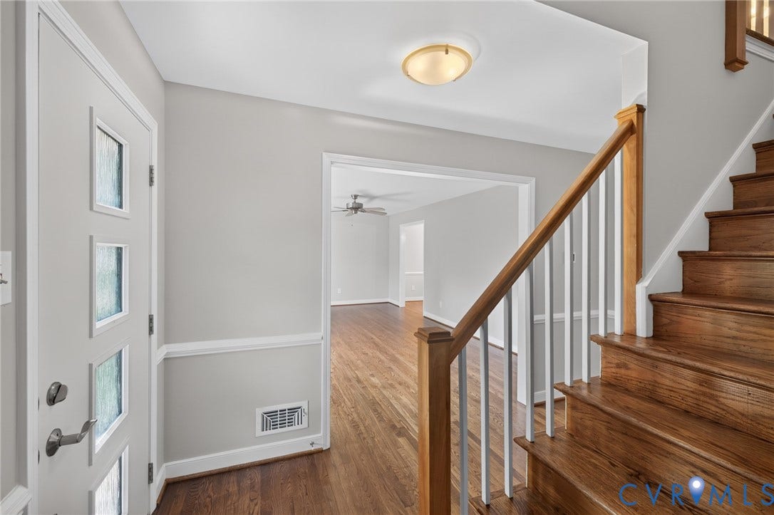 2317 Pleasant Run Drive, Henrico, VA 23238 Entryway featuring a contemporary door with frosted glass inserts, wood-finish flooring, and a built-in staircase with wood treads and banister