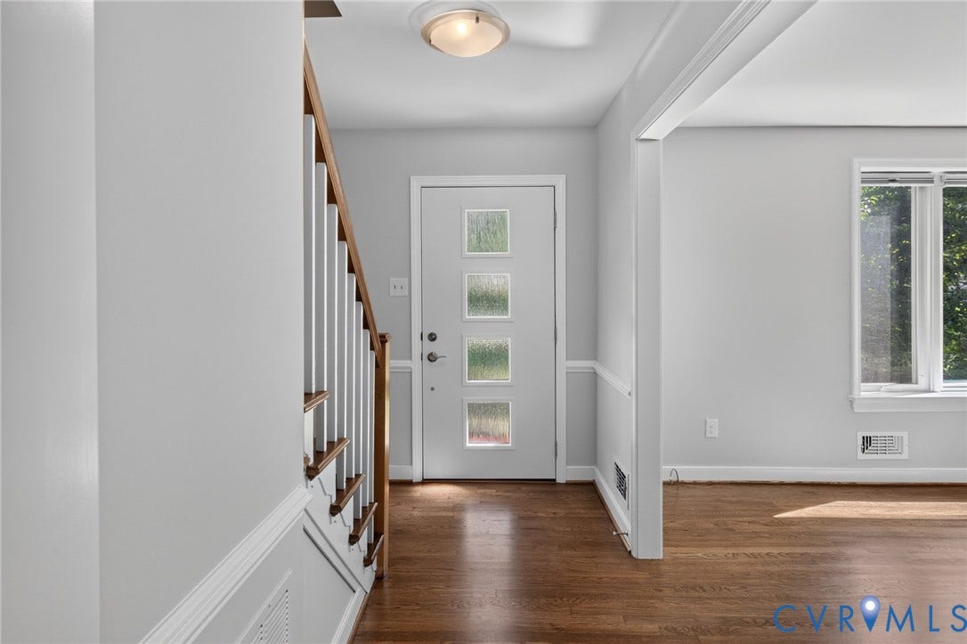 2317 Pleasant Run Drive, Henrico, VA 23238 Wood-finish flooring throughout, modern entry door with decorative glass panels, contemporary lighting fixture, and a built-in staircase with wood railing