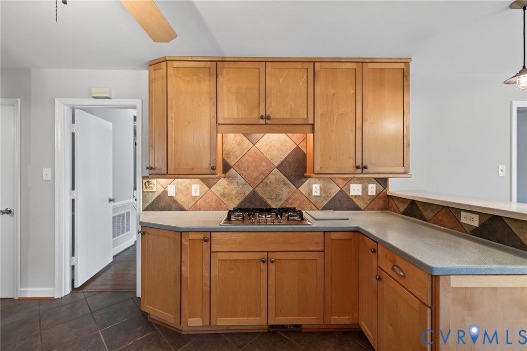 2317 Pleasant Run Drive, Henrico, VA 23238 Wood cabinetry with under-cabinet lighting, a built-in gas cooktop, and an angular tile backsplash
