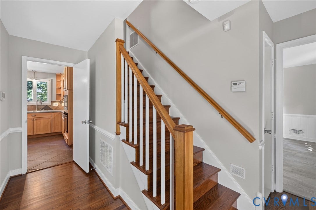 2317 Pleasant Run Drive, Henrico, VA 23238 Hardwood flooring extending into the kitchen and a staircase with wood-finish handrails