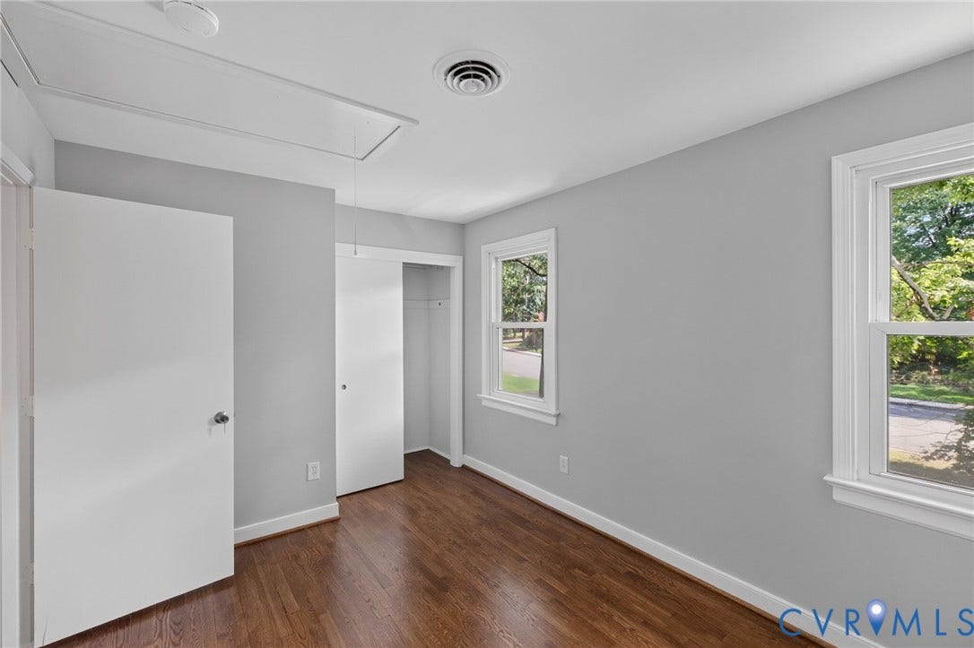 2317 Pleasant Run Drive, Henrico, VA 23238 Wood-finish flooring, light grey painted walls, white trim, two windows, and a built-in closet with sliding doors