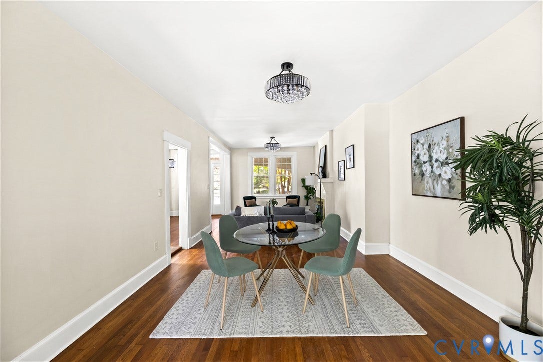 Rich wood-finish flooring, light neutral wall paint, and a crystal-detail semi-flush mount ceiling fixture