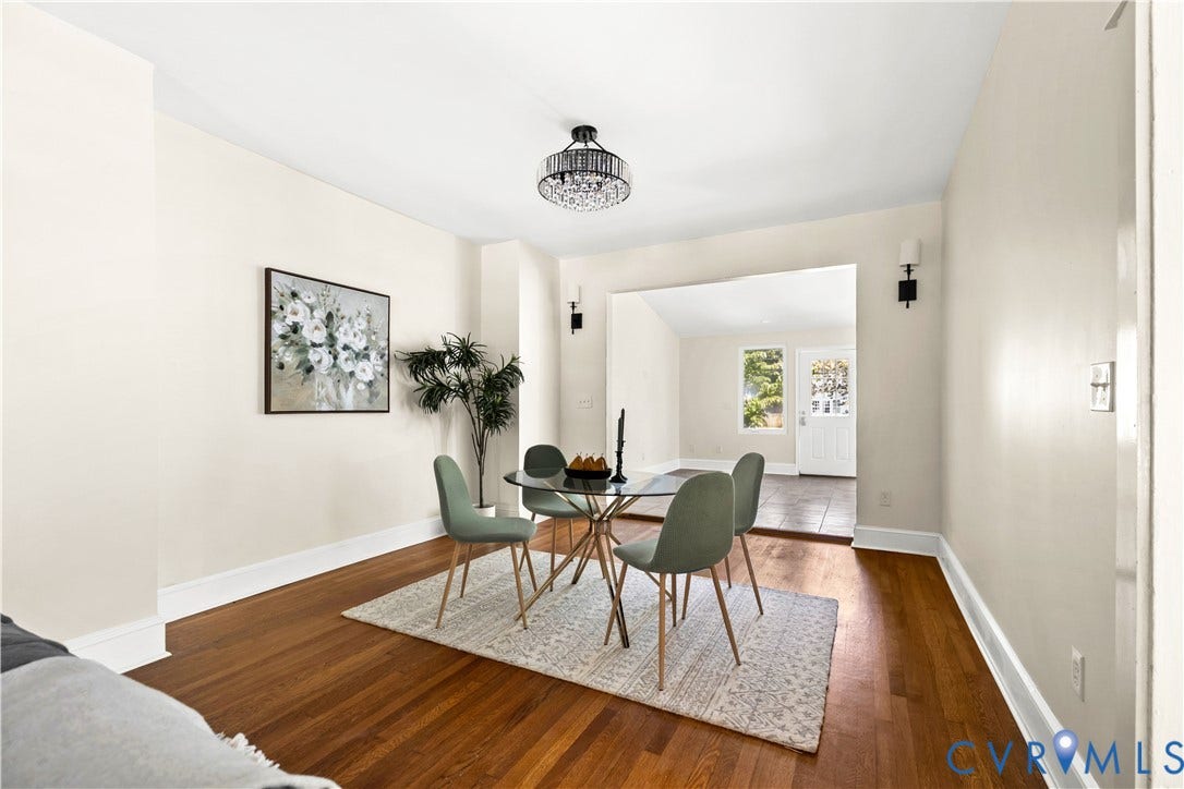Hardwood flooring throughout, recessed archway, modern chandelier, wall sconces, and neutral wall tones
