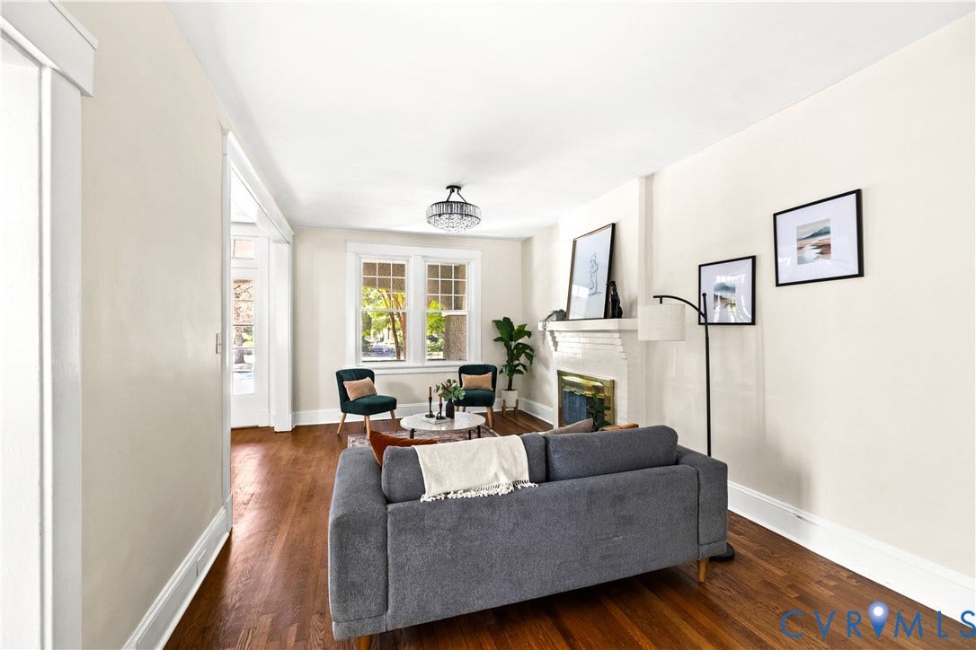 Hardwood flooring, a decorative fireplace, large windows, and a semi-flush mount ceiling fixture