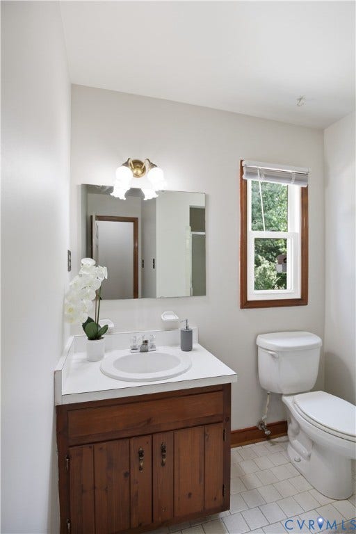 3231 Ludgate Road, Chester, VA 23831 Bathroom featuring a wood vanity with a white countertop and integrated sink, a wall-mounted mirror, and a window with wood trim