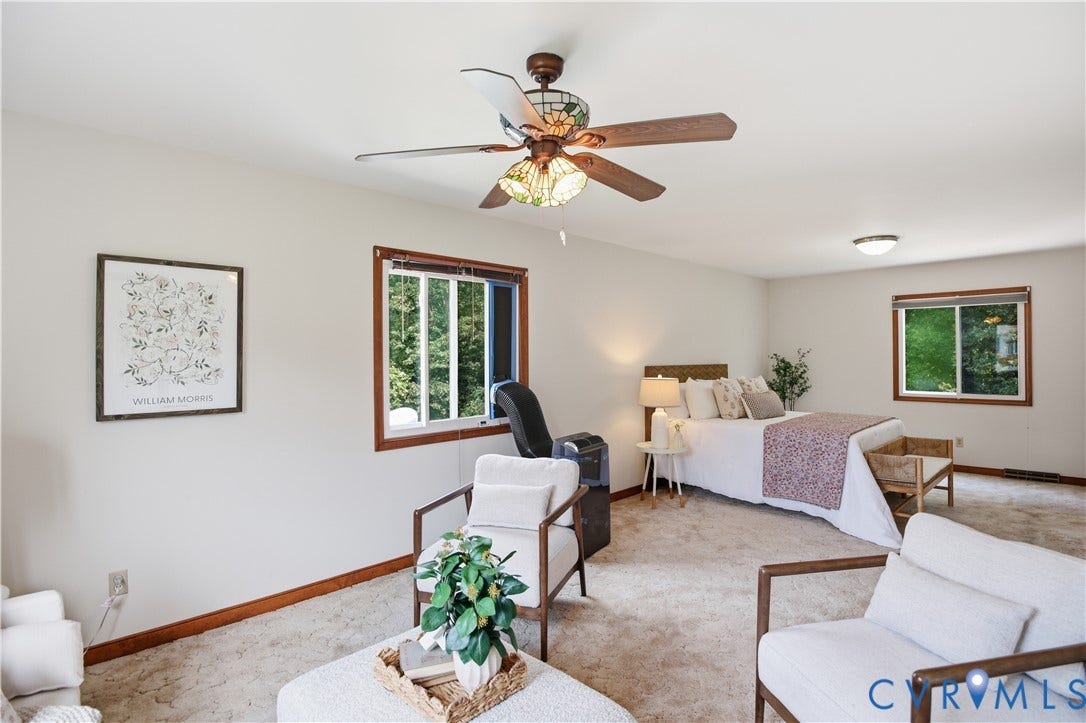 3231 Ludgate Road, Chester, VA 23831 Spacious room featuring neutral carpet flooring, multiple windows with wood trim, a ceiling fan with integrated lighting, and a flush-mount ceiling light fixture