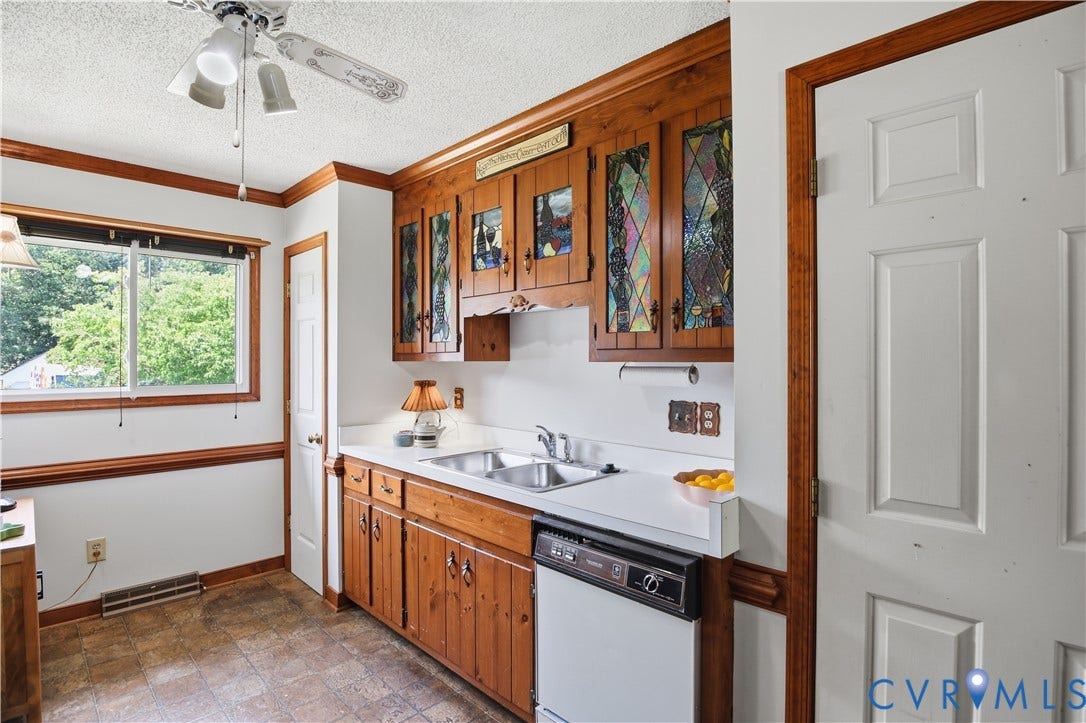 3231 Ludgate Road, Chester, VA 23831 Kitchen featuring wood cabinetry with stained glass inserts, a double basin stainless steel sink, and white countertops