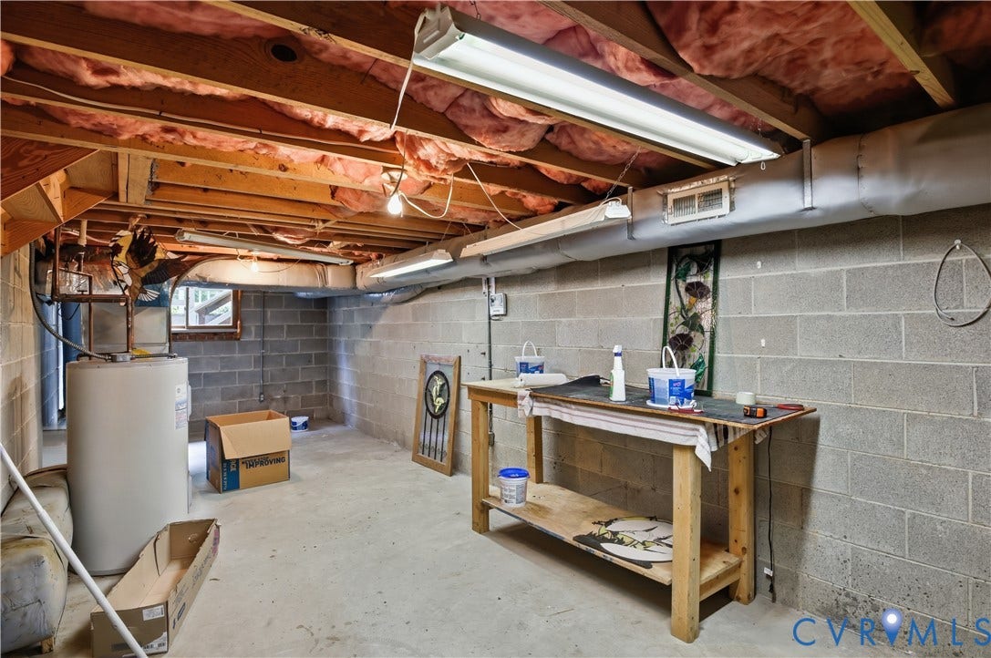 3231 Ludgate Road, Chester, VA 23831 Basement area with exposed wood joists, concrete block walls, a water heater, and a small window