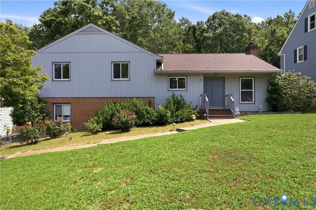 3231 Ludgate Road, Chester, VA 23831 Split-level exterior featuring light-colored siding, brick accents, a gabled roofline, and established landscaping