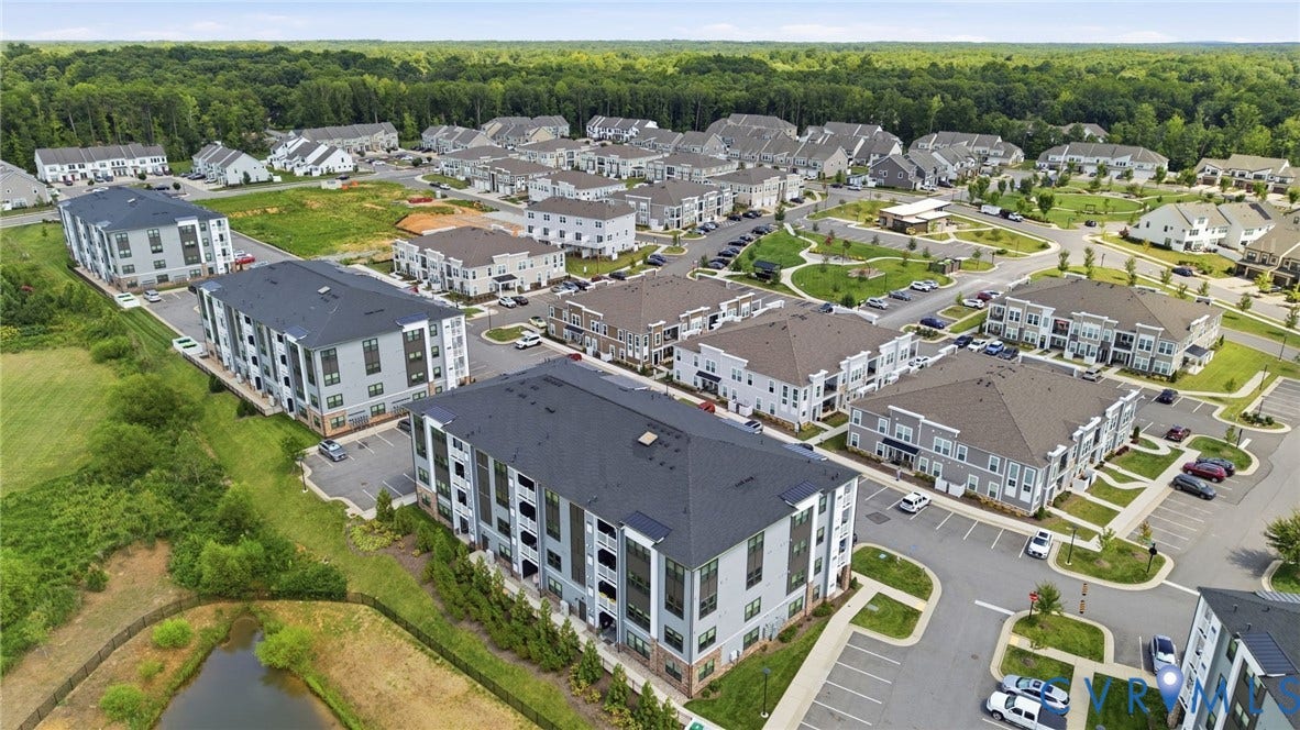 3900 Maze Runner Drive, #403, Midlothian, VA 23112 Community featuring multi-story residential buildings, ample parking, green spaces, and surrounding natural areas