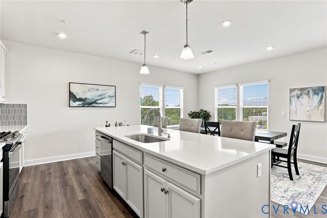 3900 Maze Runner Drive, #403, Midlothian, VA 23112 Spacious open-concept kitchen featuring a large island with a sink, stainless steel appliances, and wood-finish flooring
