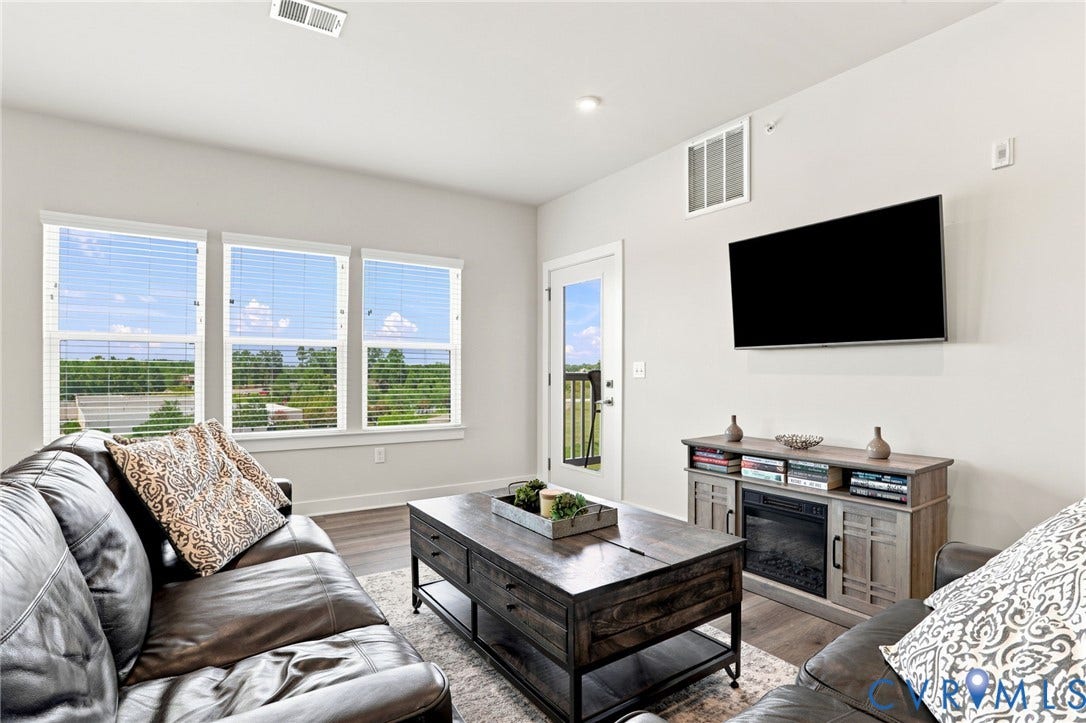 3900 Maze Runner Drive, #403, Midlothian, VA 23112 Living area featuring wood-finish flooring, multiple windows with horizontal blinds, and a glass-paneled exterior door