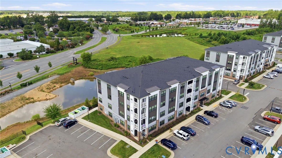 3900 Maze Runner Drive, #403, Midlothian, VA 23112 Contemporary multi-story buildings featuring balconies, surface parking, and a nearby pond