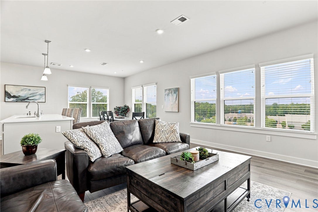 3900 Maze Runner Drive, #403, Midlothian, VA 23112 Spacious open-concept living area featuring recessed lighting, large windows with blinds, light wood-finish flooring, and a kitchen island with pendant lighting and an integrated sink
