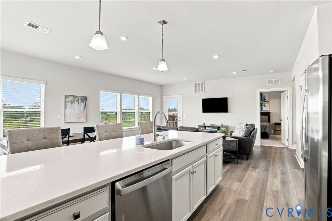 3900 Maze Runner Drive, #403, Midlothian, VA 23112 Kitchen island with an undermount sink, stainless steel appliances, and pendant lighting