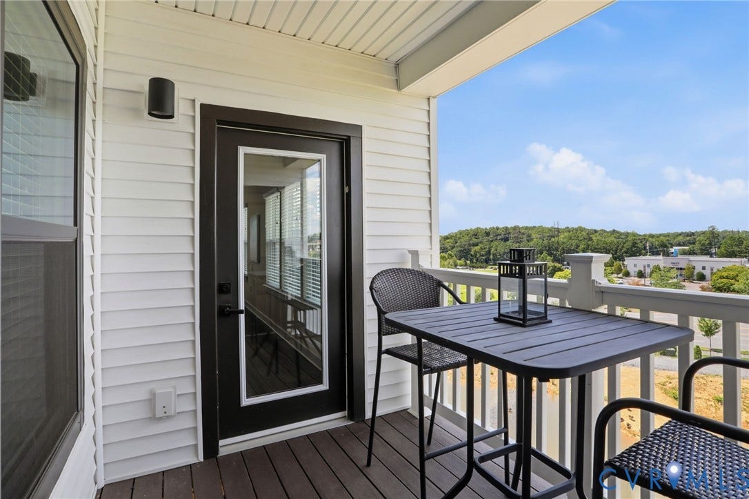 3900 Maze Runner Drive, #403, Midlothian, VA 23112 Covered outdoor balcony with wood-floors, and a black exterior door with a full-light glass panel