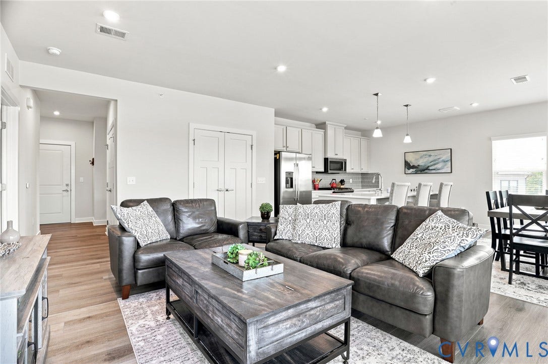 3900 Maze Runner Drive, #403, Midlothian, VA 23112 Open-concept living area with wood-finish flooring, recessed lighting, and kitchen with stainless steel appliances, white cabinetry, and pendant lighting