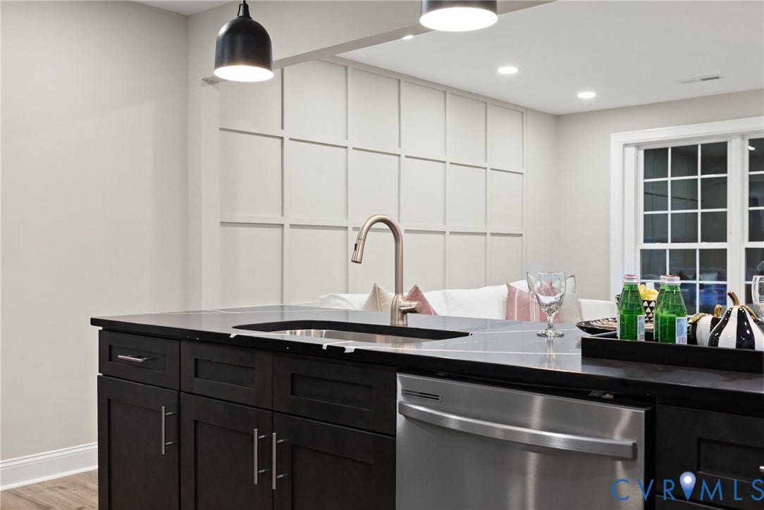 1500 Leicester Road, Cedarhurst - Westover Hills, Richmond, VA 23225 Kitchen island with dark wood cabinetry, integrated sink with gooseneck faucet, and stainless steel dishwasher