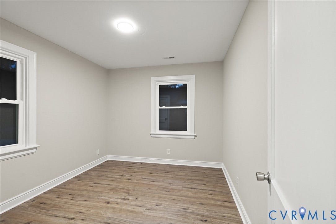1500 Leicester Road, Cedarhurst - Westover Hills, Richmond, VA 23225 Recessed ceiling lighting, wood-finish flooring, two windows with white trim, white wall finishes, and a white door with a brushed nickel handle