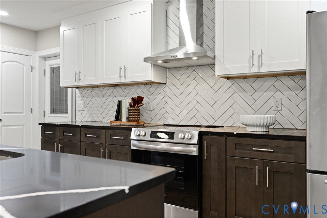 1500 Leicester Road, Cedarhurst - Westover Hills, Richmond, VA 23225 Two-tone cabinetry with contrasting finishes, white herringbone tile backsplash, stainless steel range with overhead ventilation, dark countertops, and a kitchen island with a light veining pattern