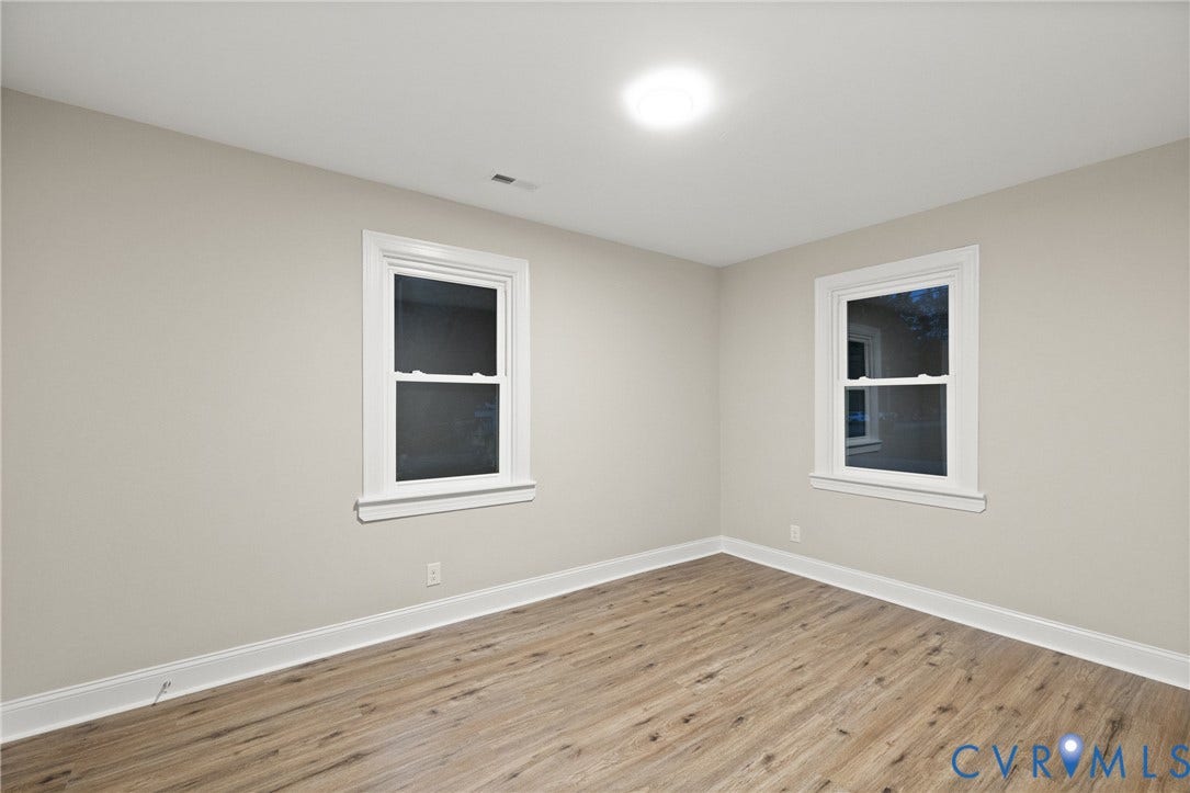 1500 Leicester Road, Cedarhurst - Westover Hills, Richmond, VA 23225 Neutral wall paint, wood-finish flooring, two windows with white trim, white baseboards, and a ceiling-mounted light fixture