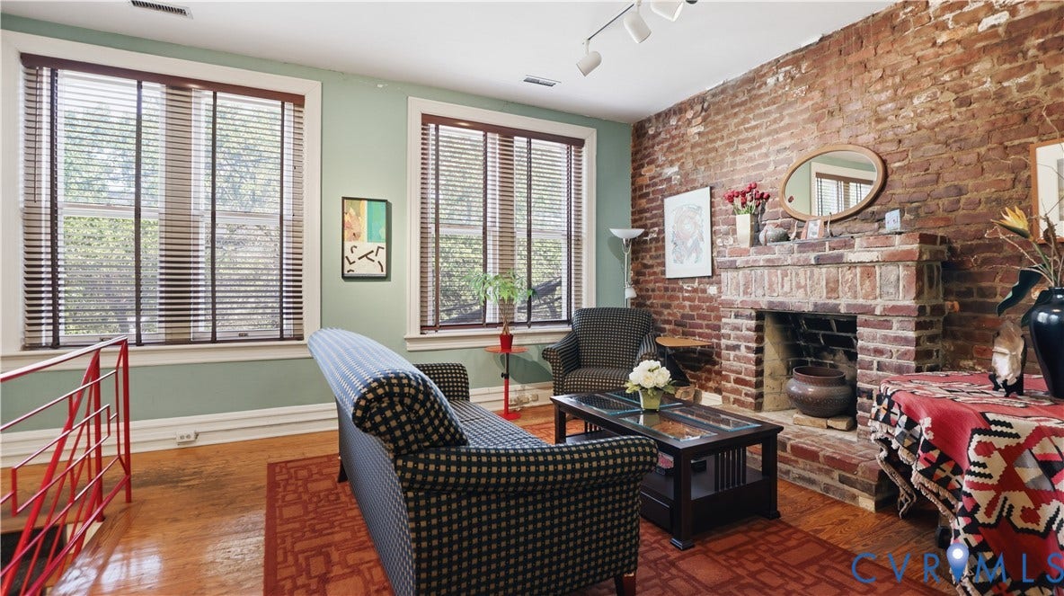 111 N 17th Street, Richmond, VA 23219 Exposed brick wall with a brick fireplace, track lighting, and wood-finish flooring