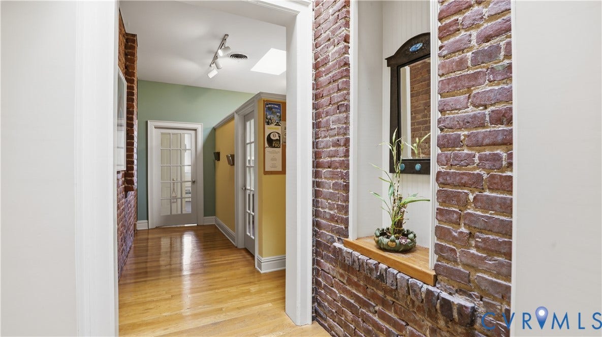 111 N 17th Street, Richmond, VA 23219 Exposed brick wall with wood sill, hardwood flooring, recessed lighting, and a skylight