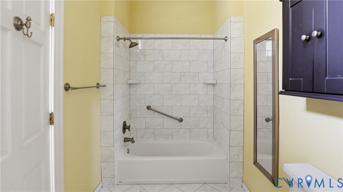 111 N 17th Street, Richmond, VA 23219 Bathtub with white subway tile surround, bronze-finish fixtures, and integrated grab bar