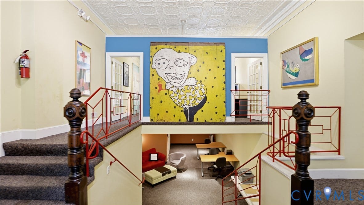 111 N 17th Street, Richmond, VA 23219 Carpeted staircase with an ornate wood newel post and red metal railing