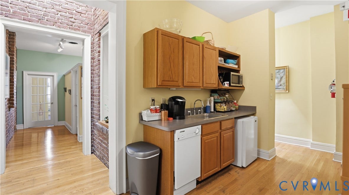 111 N 17th Street, Richmond, VA 23219 Wood-finish flooring, exposed brick wall accents, built-in cabinetry, integrated sink, and a built-in dishwasher