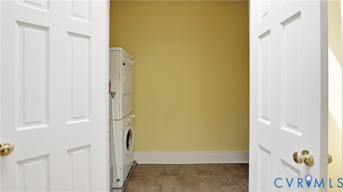 111 N 17th Street, Richmond, VA 23219 Laundry area featuring a stacked washer and dryer, tile flooring, and white trim
