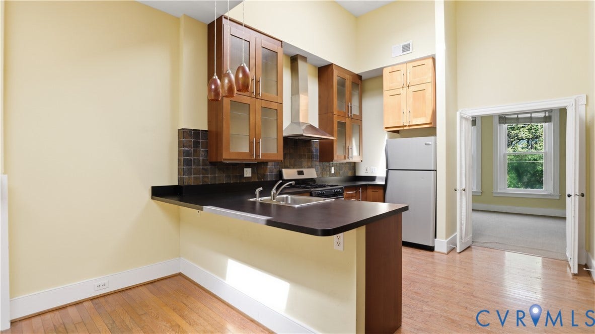 111 N 17th Street, Richmond, VA 23219 Kitchen featuring wood-finish flooring, dark countertops, a stainless steel refrigerator, and recessed lighting