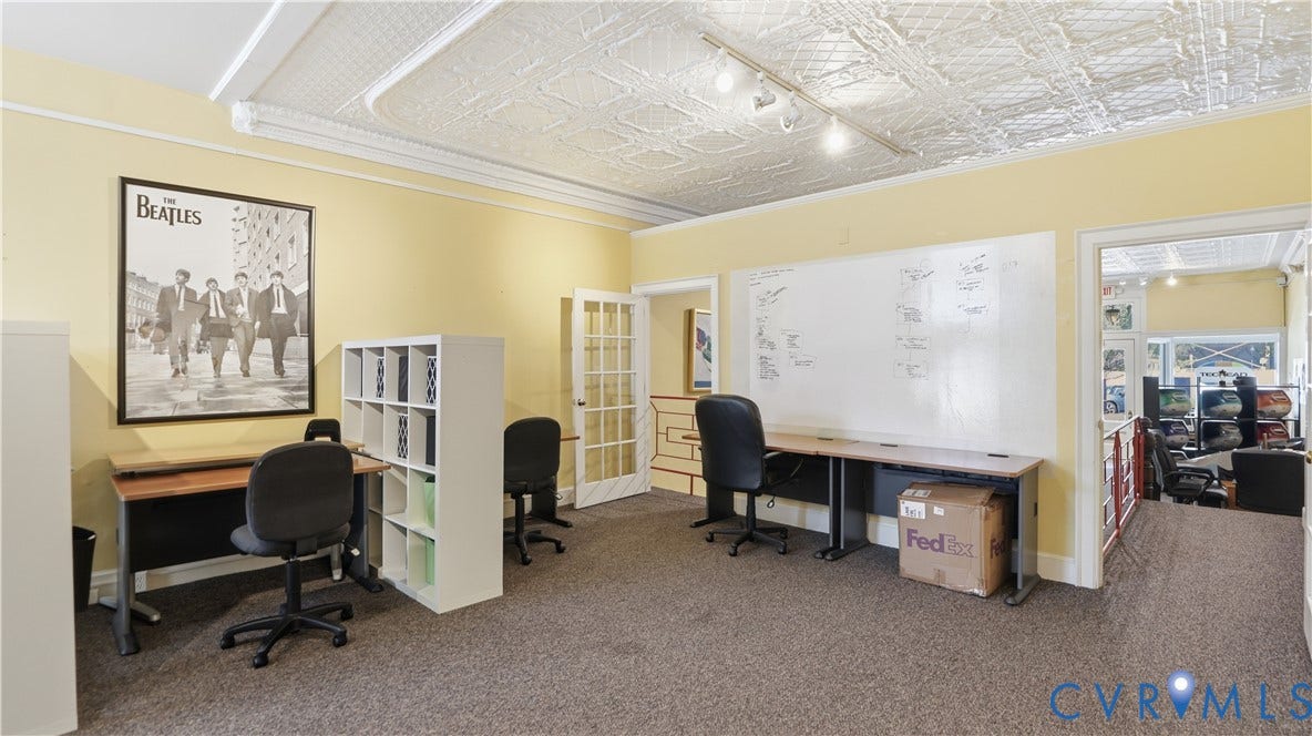 111 N 17th Street, Richmond, VA 23219 Textured ceiling with track lighting, multiple built-in desks, wall-mounted whiteboard, and a glass-paneled door